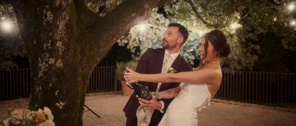 The bride and groom open champagne