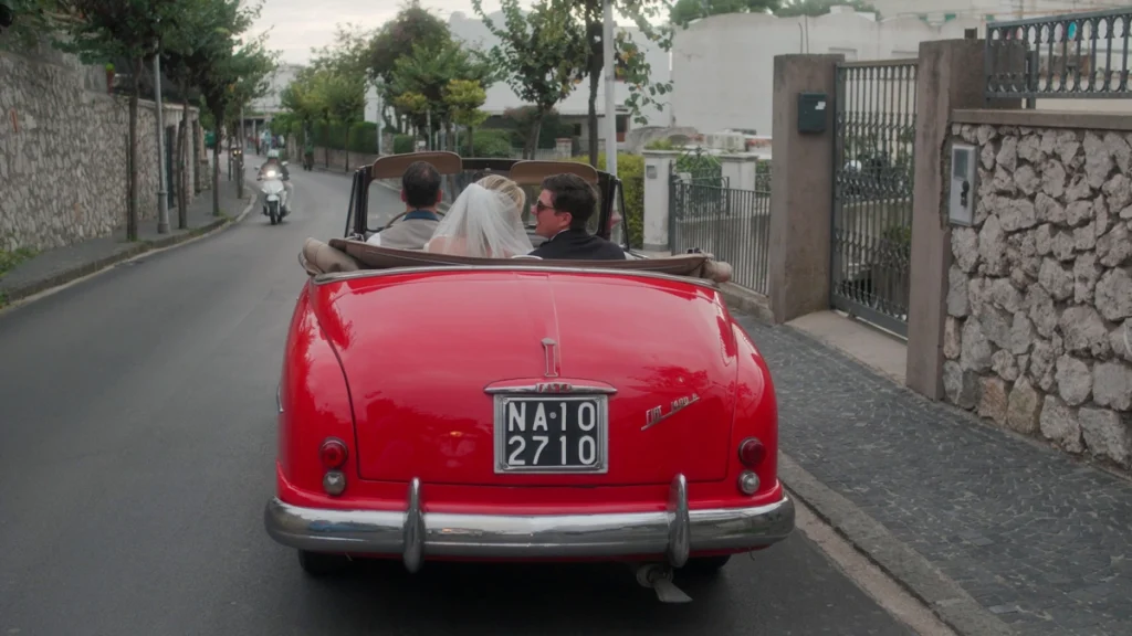 The newlyweds driving around in an old italian car