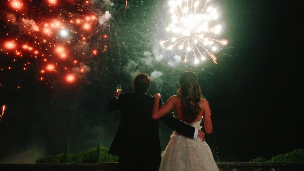 The couple watches fireworks after the cake cutting