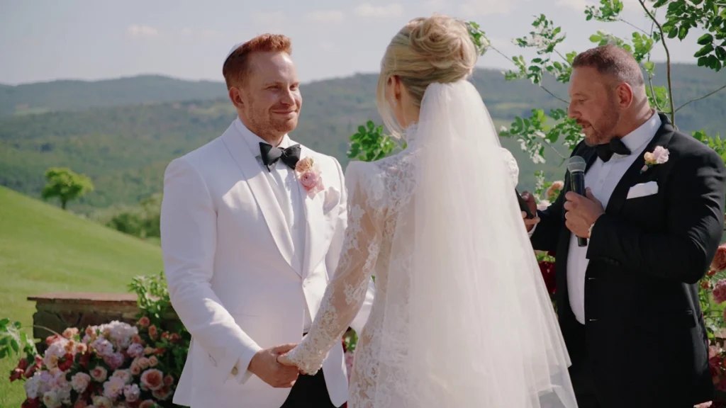 The groom smiles as he looks at his wife