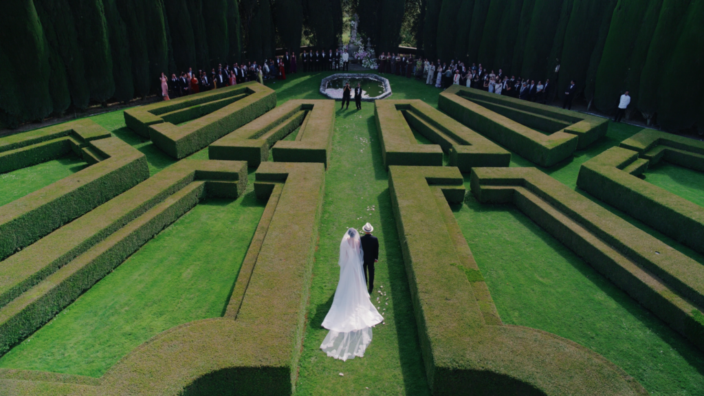 the bride accompanied by her father through the Italian garden