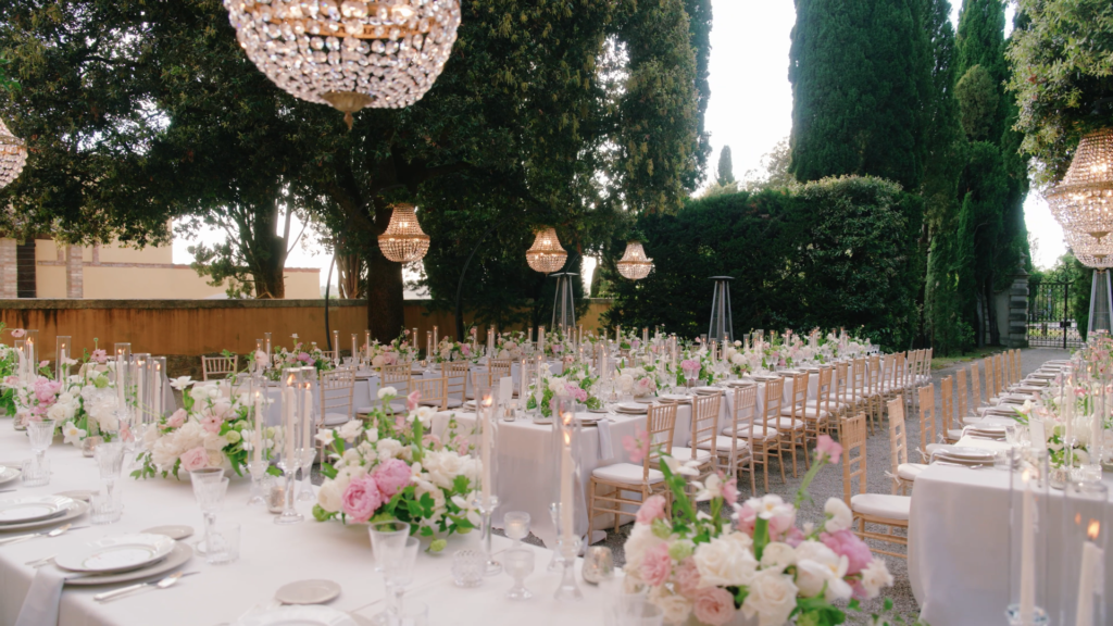 Outdoor wedding tables decorated with floral arrangements.